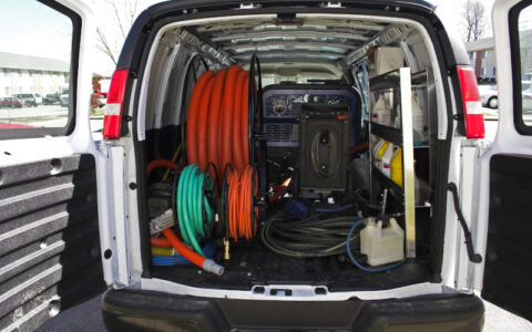 View of a van with open doors showing built-in steam cleaning equipment